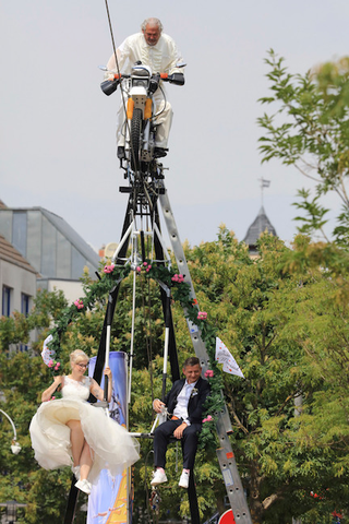 Illustration for article titled Saturday Night Social: Congrats to This Couple Who Wedded on a Swing Hanging from a Motorcycle on a Tightrope!